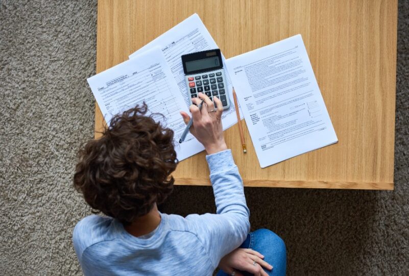 Persona revisando una declaración complementaria de la renta con documentos fiscales y calculadora